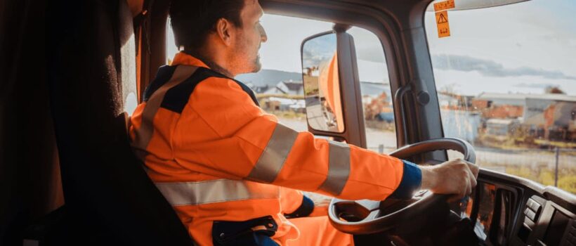 Solid waste worker driving a waste truck