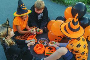 kids sorting unopened halloween candy while having fun with decorations