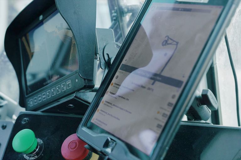 Fleet trucks and dashboards showing waste hauling service analytics and real-time route performance.